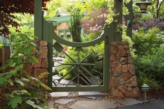A garden gate made out of old gardening tools.
