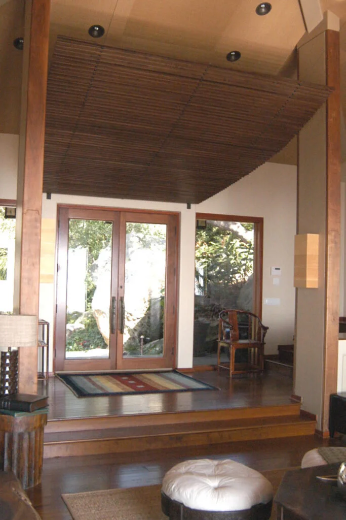 In this home which had a modern tropical feel to it, we used a simple wood and glass door, but then, using the same teak, we created a slat awning that amplifies the effect of the door.