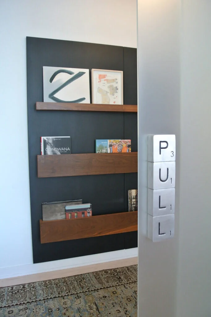A door handle that looks like silver scrabble tiles and reads PULL.